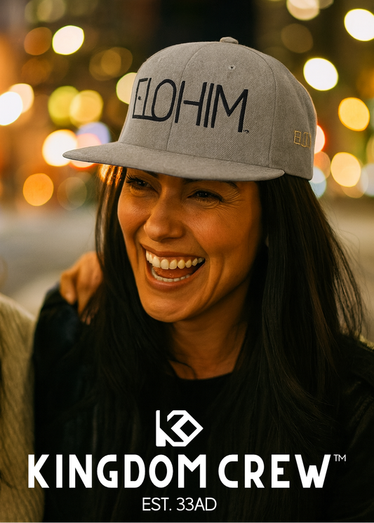 Person wearing a cap with 'ELOHIM' text, smiling, against a blurred festive background with 'Kingdom Crew' branding.