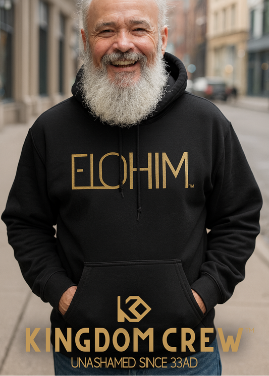 Man wearing a black hoodie with 'ELOHIM' and 'Kingdom Crew' text on a city street.