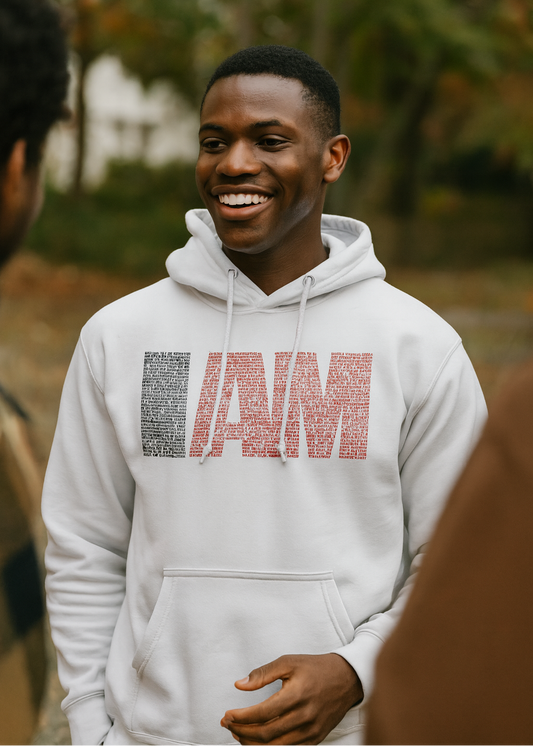 Man wearing a gray hoodie with text design, standing outdoors.