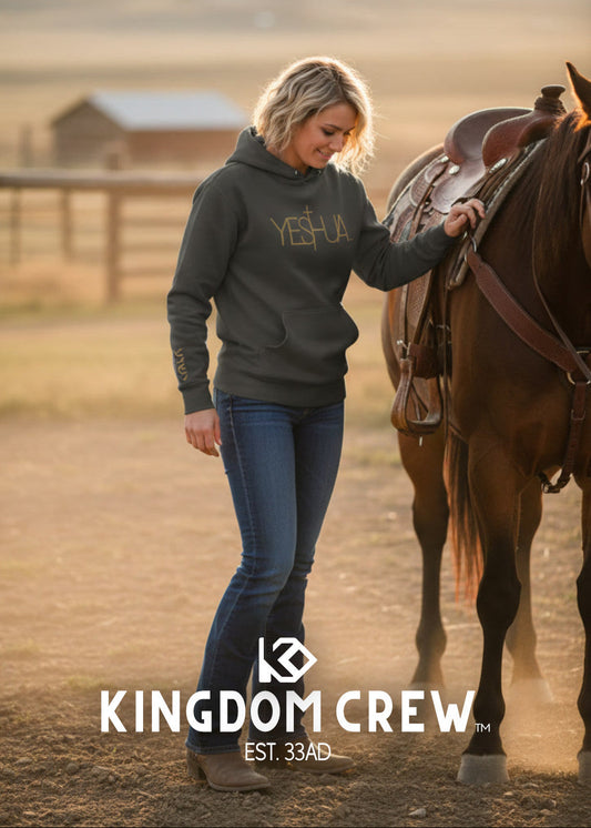 Woman in a hoodie standing next to a horse with 'Kingdom Crew' branding.
