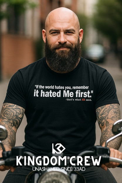 Man with tattoos and a beard wearing a black t-shirt with a quote, sitting on a motorcycle with 'Kingdom Crew' branding.