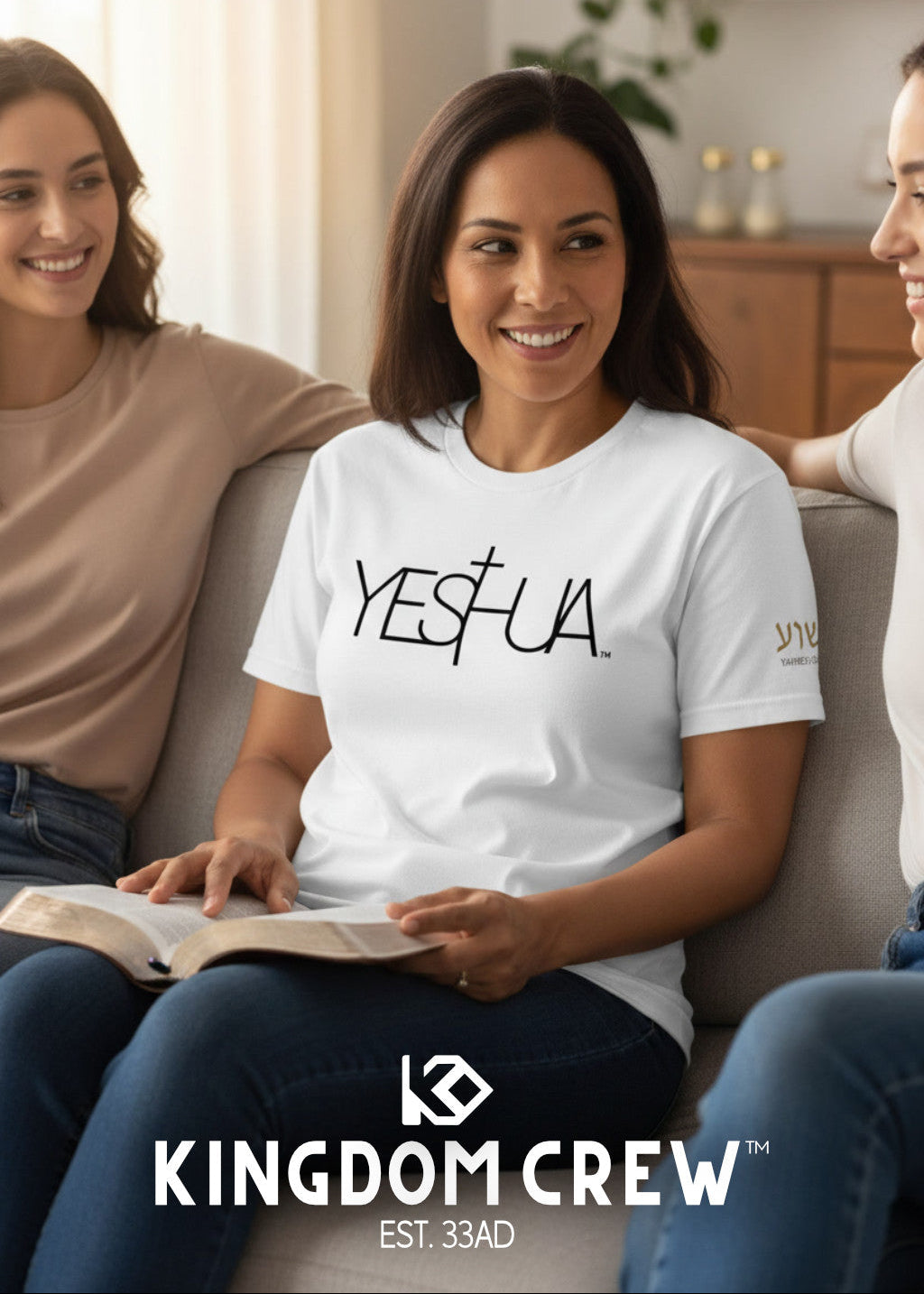 Three women sitting on a couch with one wearing a 'YESUA' shirt, in a home setting.
