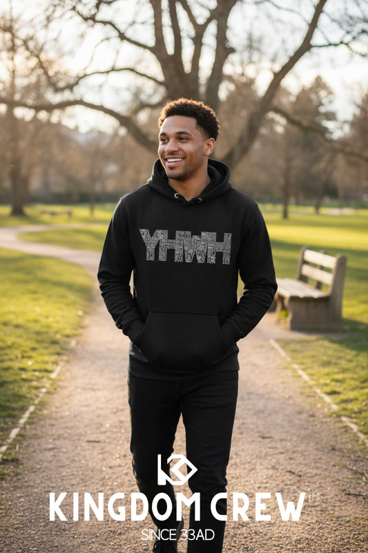 Man wearing a black hoodie with text in a park, featuring 'Kingdom Crew' branding.